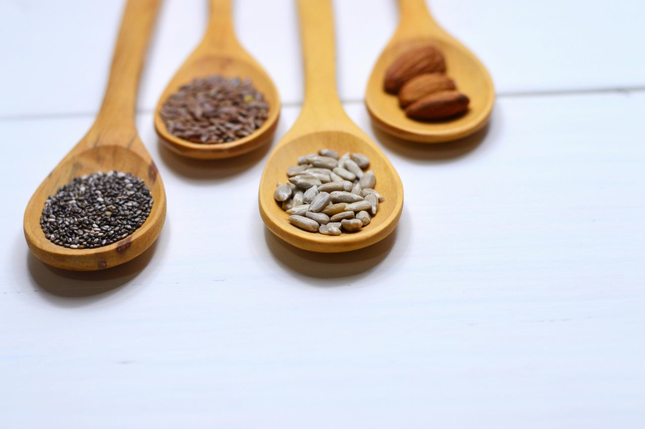 pumpkin seeds, chia seeds, flaxseeds, sunflower seeds on spoons