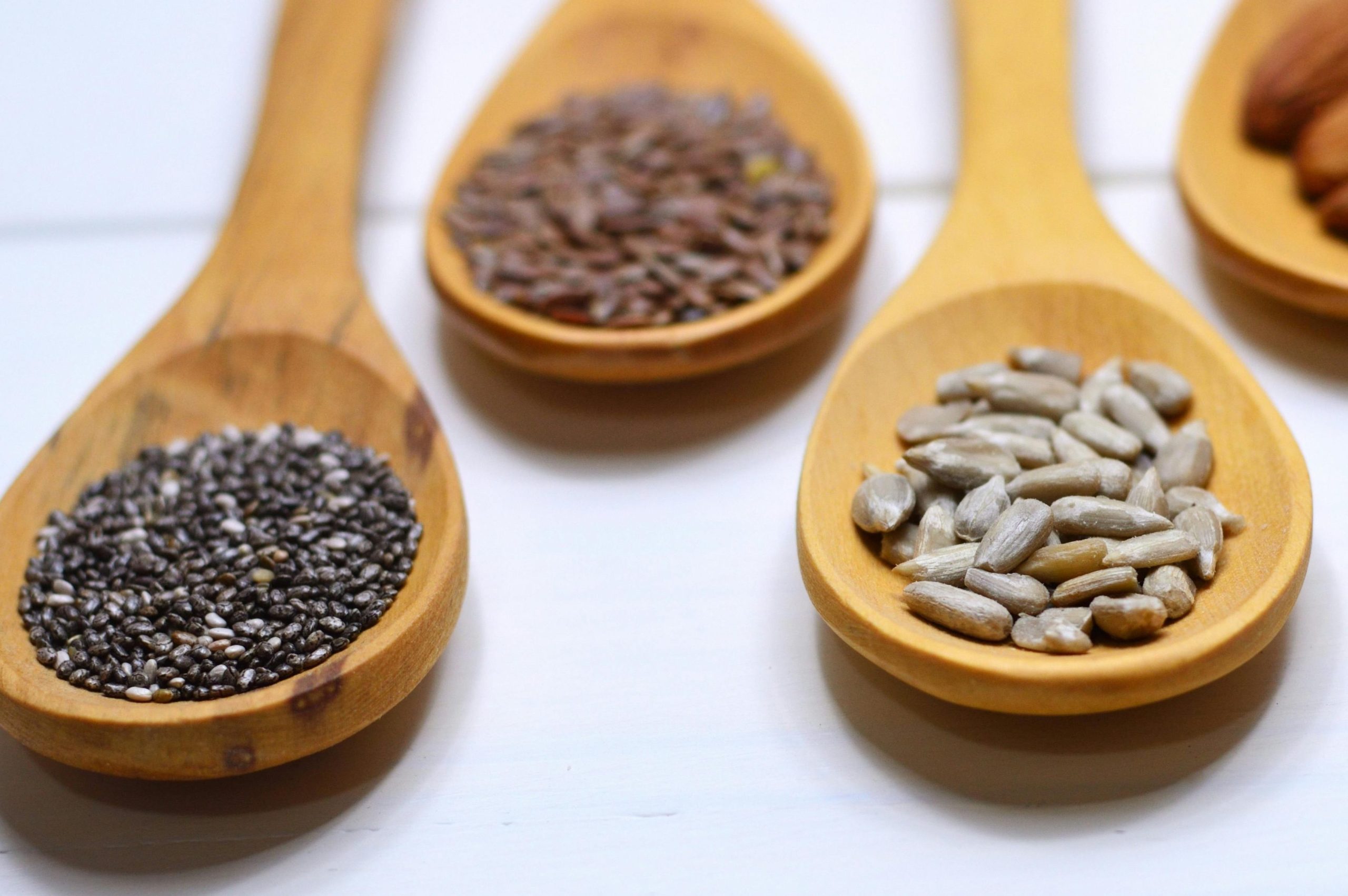 pumpkin seeds, chia seeds, flaxseeds, sunflower seeds on spoons