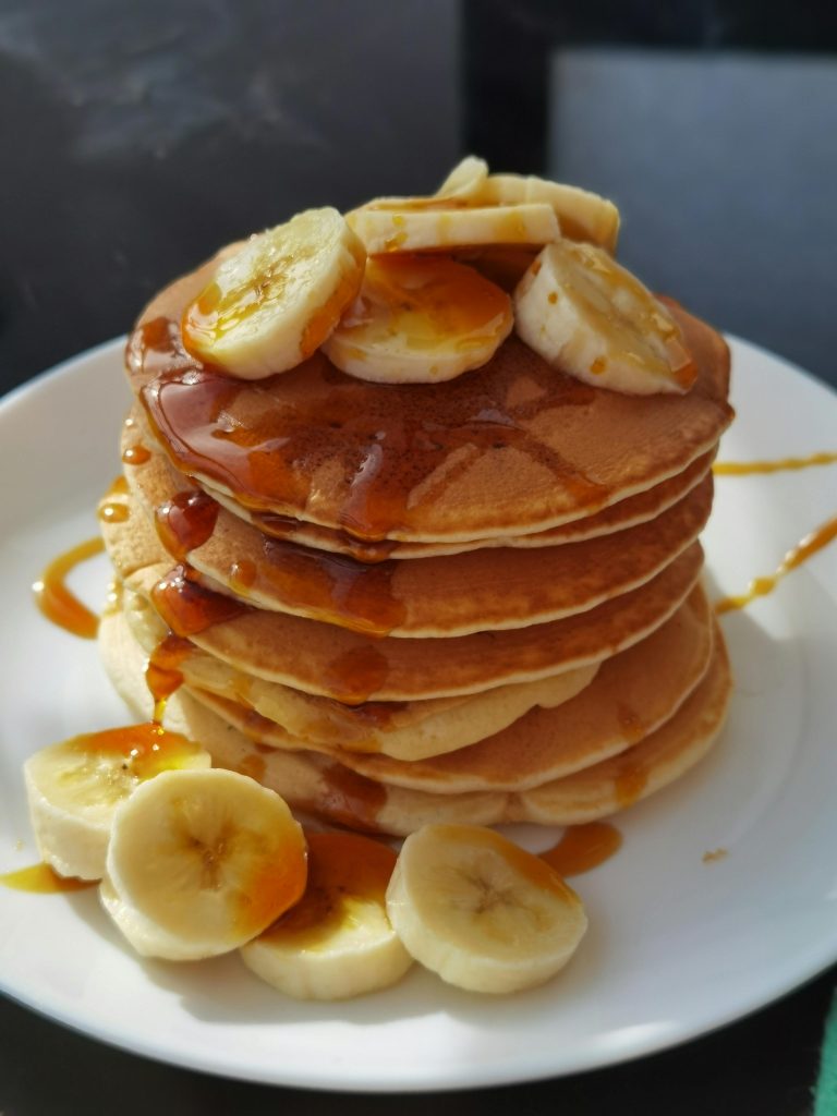 oats pancakes with a drizzle of honey and sliced banana
