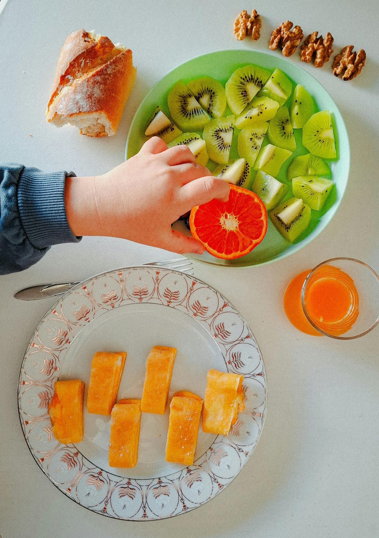 toddler picking some fruits from a plate